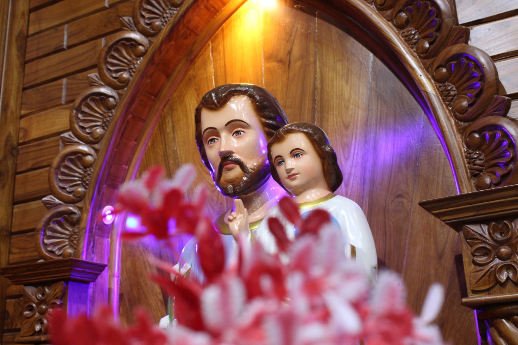 Statue of Saint Joseph with the child Jesus in a carved wooden niche